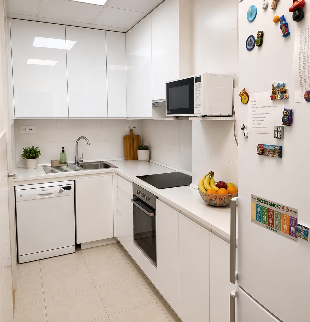 La cocina del centro, con la vitrocerámica, el horno y el frutero sobre la encimera